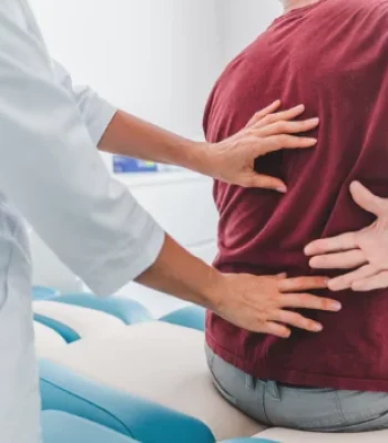 Orthopäde behandelt Patient mit Rückenbeschwerden