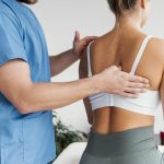 side view male osteopathic therapist checking female patient s scapula bone scaled